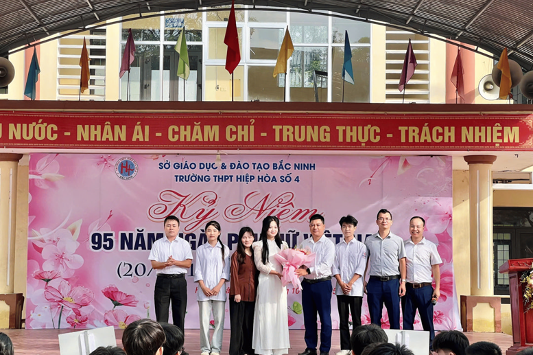 Đại diện BGH nhà trường tặng hoa chúc mừng các em học sinh nữ