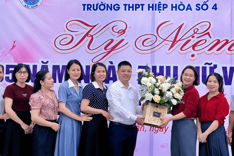 Đại diện BGH nhà trường tặng hoa chúc mừng các nữ giáo viên, nhân viên